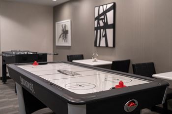 a table with a hockey puck on it in a room with other tables and chairs at Sky on Main in Kansas City, Missouri